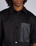 CAMICIA NERA CON TASCA IN ECOPELLE E LOGO METALLICO